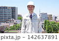 A male site supervisor walks with a smile under the blue sky. 142637891