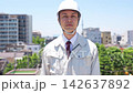 A male site supervisor walks with a serious expression under a blue sky. 142637892
