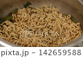 Eating hot noodle soup from a metal bowl close-up 142659588