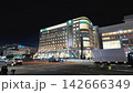 Nighttime cityscape of Sapporo Station area featuring bright neon commercial buildings and passing traffic on a summer night in Hokkaido, Japan 142666349