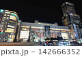 Nighttime cityscape of Sapporo Station area featuring bright neon commercial buildings and passing traffic on a summer night in Hokkaido, Japan 142666352