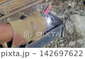 Worker hand in glove welds metal details in workshop 142697622