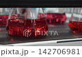 Lab shaker. Scientific orbital shaker mixing liquid solutions in Erlenmeyer flasks or test tubes. Medical chemical or biotechnology research pharmaceutical laboratory experiments and scientific tech. 142706981