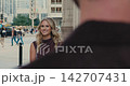 Beautiful blonde woman smiling at her partner on a city street 142707431