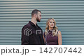 A loving couple against a modern gray wall. The boy gently kisses the girl. A romantic moment in their relationship. 142707442