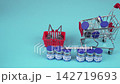 Peptide Vials with Syringe, Mini Shopping Cart and Basket on Blue Background 142719693