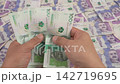 Person counting colombian pesos banknotes over a pile of money 142719695