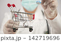 Doctor Holding Peptide Ipamorelin Vial and Mini Shopping Cart, Healthcare Consumer Concept 142719696