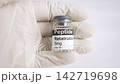 Gloved hand holding an retatrutide peptide vial 142719698