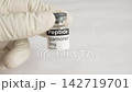 Gloved hand holding ipamorelin peptide vial 142719701