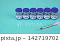 Peptide Vials and Insulin Syringe on Blue Background, Vertical Close Up 142719702