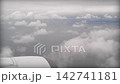 離陸直後の機内から撮影された水平線まで広がる海と雲 142741181