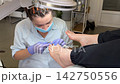 Toenail Fungus Treatment Concept with Professional Pedicure Specialist Using Electric Drill for Careful Nail Cleaning and Foot Care 142750556