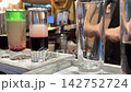 Bartender Pouring Different Alcoholic Drinks into Four Shot Glasses at a Bar 142752724