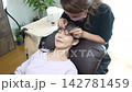 Woman receiving eyelash extension treatment 142781459