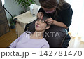 Woman receiving eyelash extension treatment 142781470