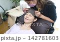Woman receiving eyelash extension treatment 142781603