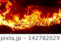 Warm Glow of Flames Dancing in a Cozy Fireplace at Night 142782029