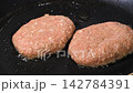 黒い鉄板で焼き目をつけて焼くハンバーグ 142784391