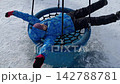 Youngster Swings Happily In Snowy Landscape.  142788781