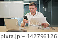 Focused Professional Comparing Data on Phone and Documents 142796126