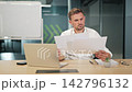 Man Reviews Business Documents In Office 142796132
