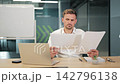 Professional Concentrates on Business Documents and Laptop at Office Desk 142796138