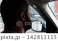 Confident bearded man looking concentrated to urban road while riding electric automobile. Guy driving the auto at highway. Serious male driver operating a motor car at town. Slow motion 142811115