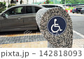 Close up of Wheelchair Accessibility Symbol on the pedestrian crossing Stone Bollard on city street road 142818093