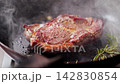 將牛排放入煎鍋中煎至表面金黃，然後淋上白蘭地。 142830854