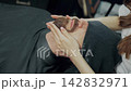 Barber Applying Lotion to Clients Beard 142832971