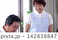 A senior man being served meals at a nursing home and a senior female staff member. 142838847