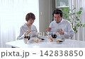 A senior couple eating a meal in the dining room. 142838850