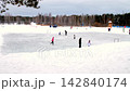 Children skate on outdoor ice arena in park near forest 142840174