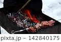 Meat roasts on charcoal barbecue outdoor in winter 142840175