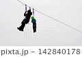 Worker rescues frightened boy hanging on zip-line rope 142840178