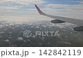 Ezeiza, Argentina - April 20, 2026: Passenger view of an airplane wing above scattered clouds and green countryside during descent toward Buenos Aires in South America. 142842119