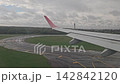 Ezeiza, Argentina - April 20, 2026: Passenger window view as an airplane touches down and rolls along a wet runway with deployed wing mechanisms at Ezeiza airport. 142842120