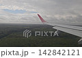 Ezeiza, Argentina - April 20, 2026: Passenger view of an airplane flying very low over forest and airport grounds during final approach to the runway in South America. 142842121