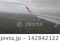 Ezeiza, Argentina - April 20, 2026: Airplane with extended flaps flies at low altitude above a large forest on final approach to Ezeiza airport in South America. 142842122