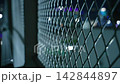 Diamond Mesh Security Fence at Night with Urban Bokeh Lights. Restricted Area Surveillance scene 142844897