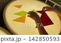 Child hands solving a colorful geometric tangram puzzle on an interactive glowing light table. Learning geometry and spatial reasoning through engaging hands-on play 142850593