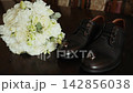 Wedding day preparation with shoes and bouquet on table 142856038