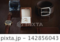 Wedding day preparation with rings, accessories, and timekeeping on the table 142856043