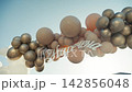 Celebration decorations at a wedding ceremony with balloons and a sign at sunset 142856048