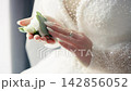 Bride holding bouquet on wedding day in a bright setting 142856052
