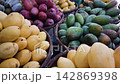 Panning shot of colorful tropical fruit including mangoes and mangosteens at local market stall 142869398