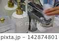 wash the chrome bathroom faucet with detergent 142874801
