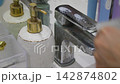 wash the chrome bathroom faucet with detergent 142874802