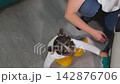 Young Caucasian educator teaches a little girl to wash the floor in a kindergarten classroom. The Montessori activity develops practical skills, coordination, and independence. Top view 142876706